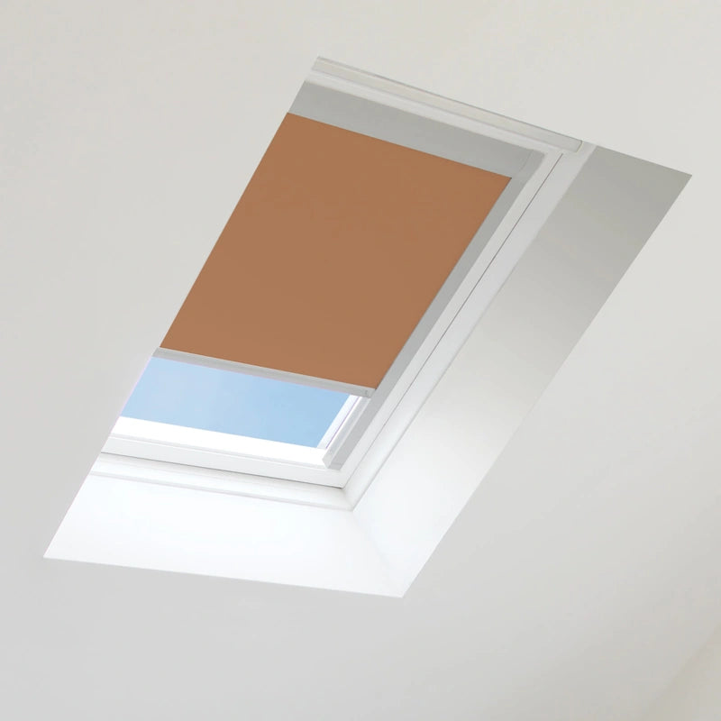 Brown roof window blind on a skylight with blue sky visible