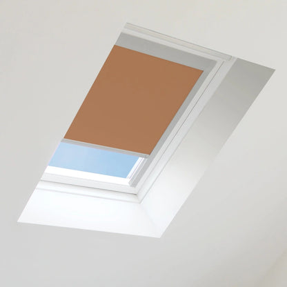 Brown roof window blind on a skylight with blue sky visible