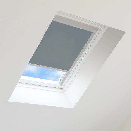 Gray roof window blind partially covering a skylight with blue sky visible
