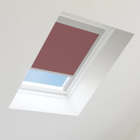 Red roof window blind on a skylight with blue sky visible