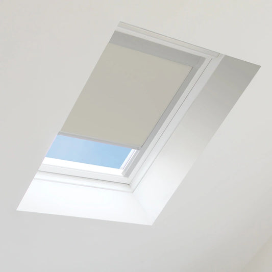 Skylight with a beige blind partially open, showing blue sky outside.