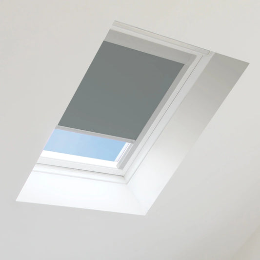 Gray skylight blind installed in a roof window with blue sky visible