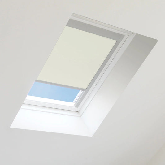 Skylight with a beige blind partially covering it, showing blue sky outside.